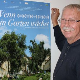Einladungsplakat "Wenn ein Garten wächst", daneben einer der Organisatoren